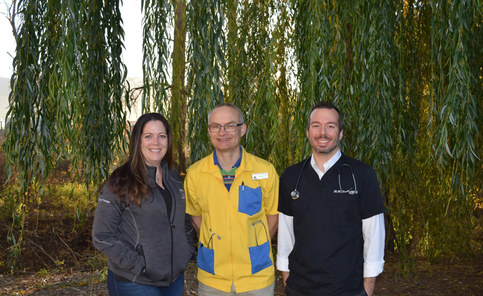 Okanagan Veterinary Hospital doctors standing in front of a leafy green background.